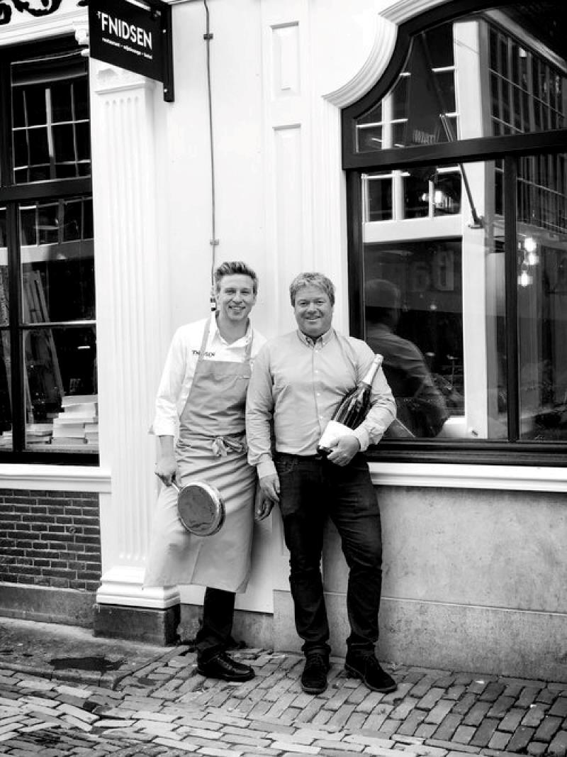 twee mannen staan voor de raam van 't Fnidsen Hotel